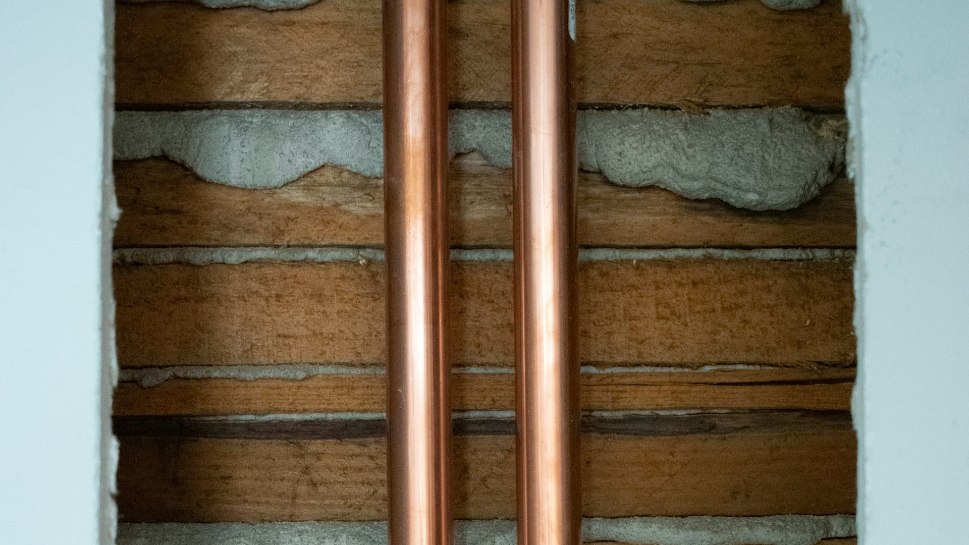 Deux tubes de cuivre neufs dans une cloison ouverte